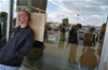 A protester leans against a placard with its message directed at consumers inside a big box shop, Bloomington, Indiana. 2001