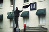 A Black Bloc Anarchist waves a black flag while standing atop traffic signal near the GAP in Washington D.C. April 16, 2000